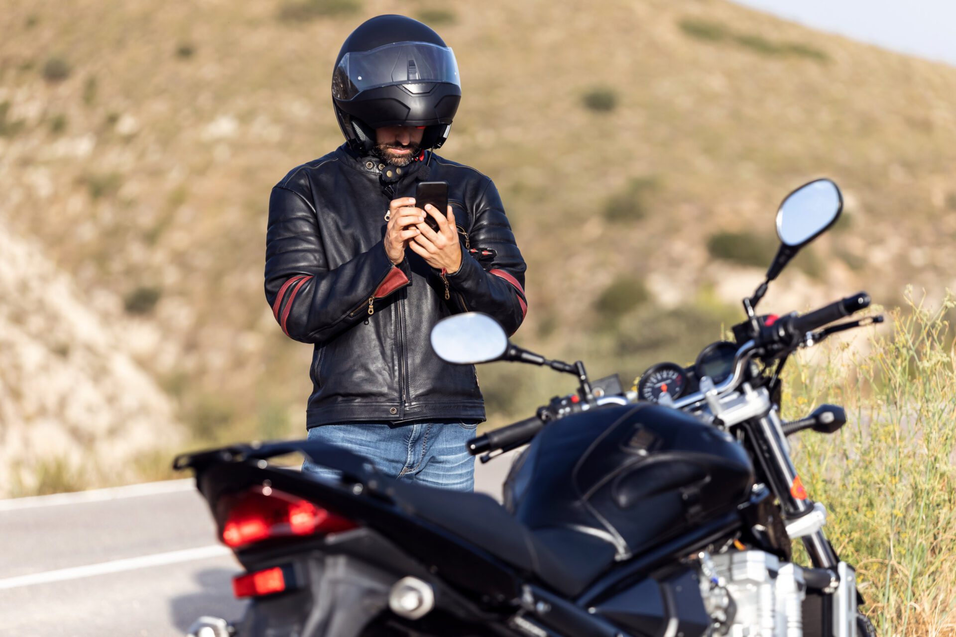 Man biker talking on the phone to the insurance of his motorcycle