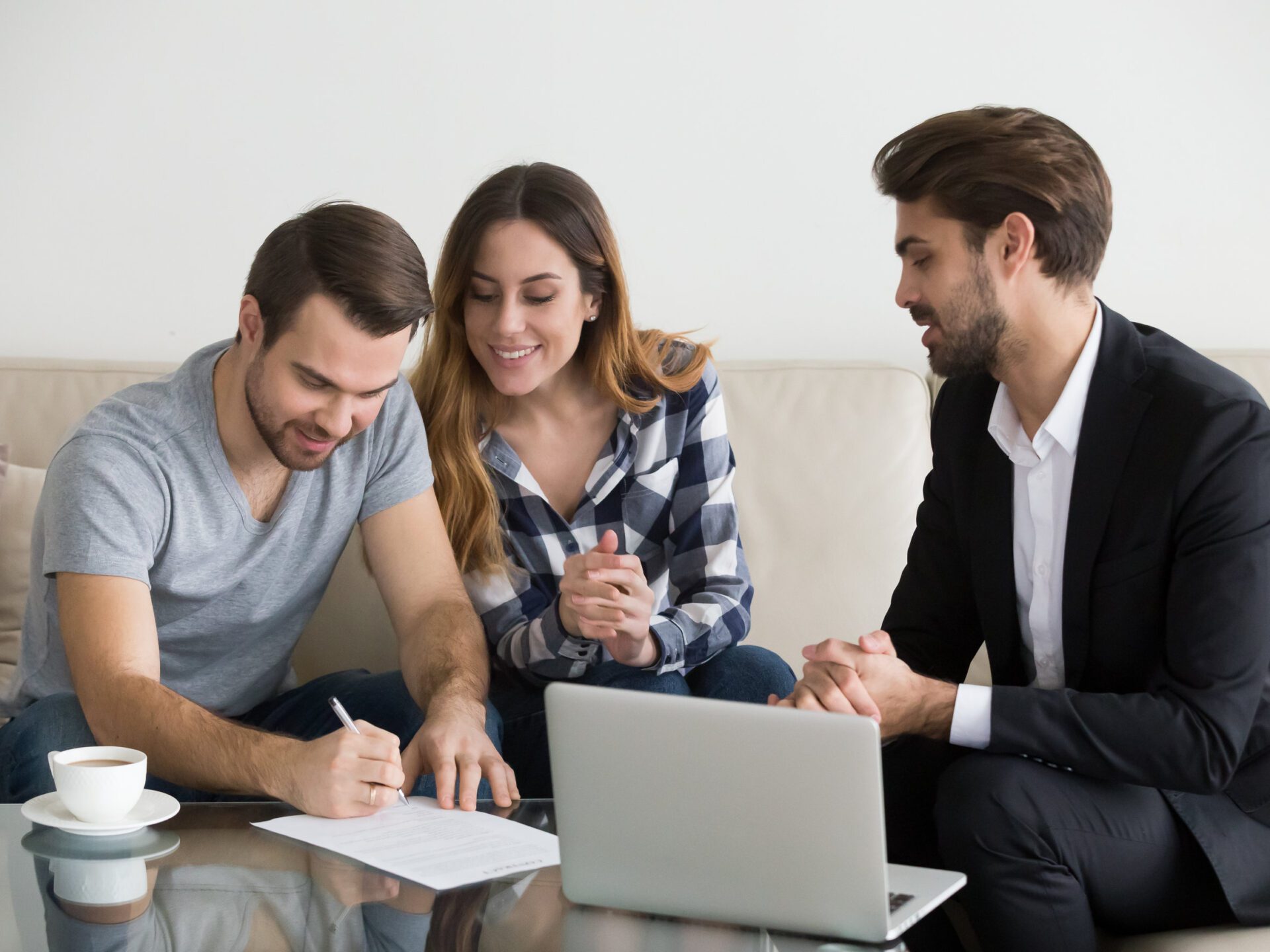 Happy couple renters or tenants sign insurance contract